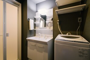 Ein Badezimmer mit Waschbecken, Spiegel und Waschmaschine.