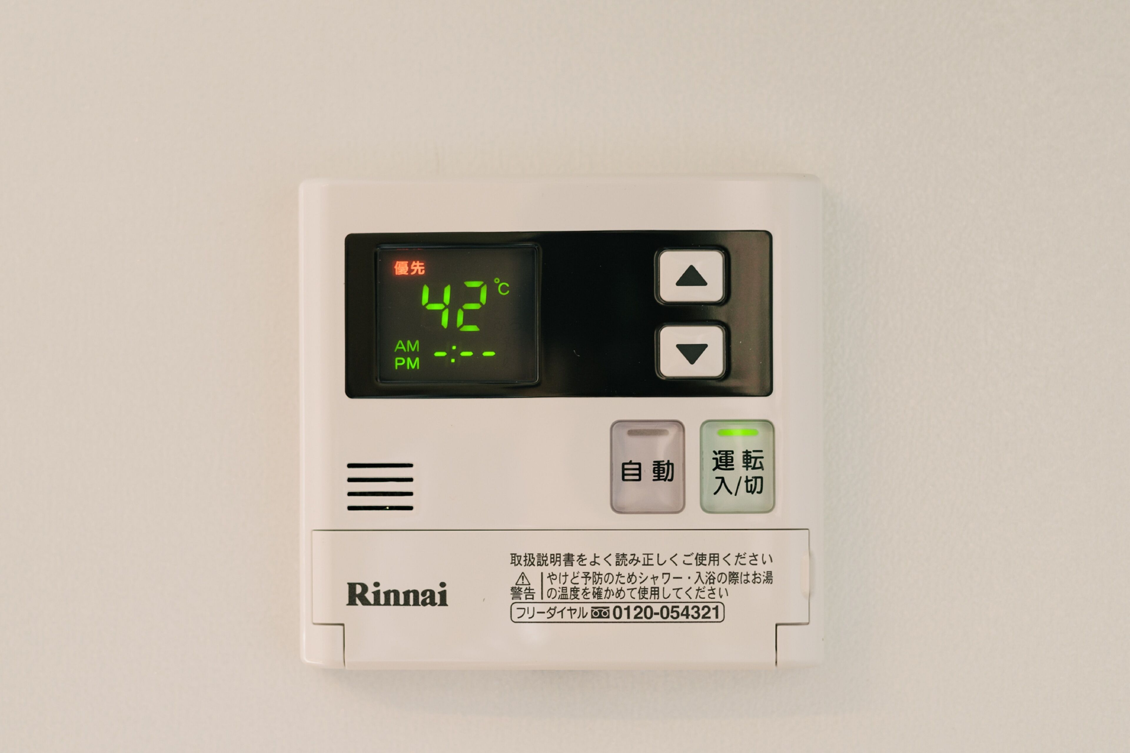 A Rinnai water heater with a digital display showing 42°C, control buttons, and a brand name.
