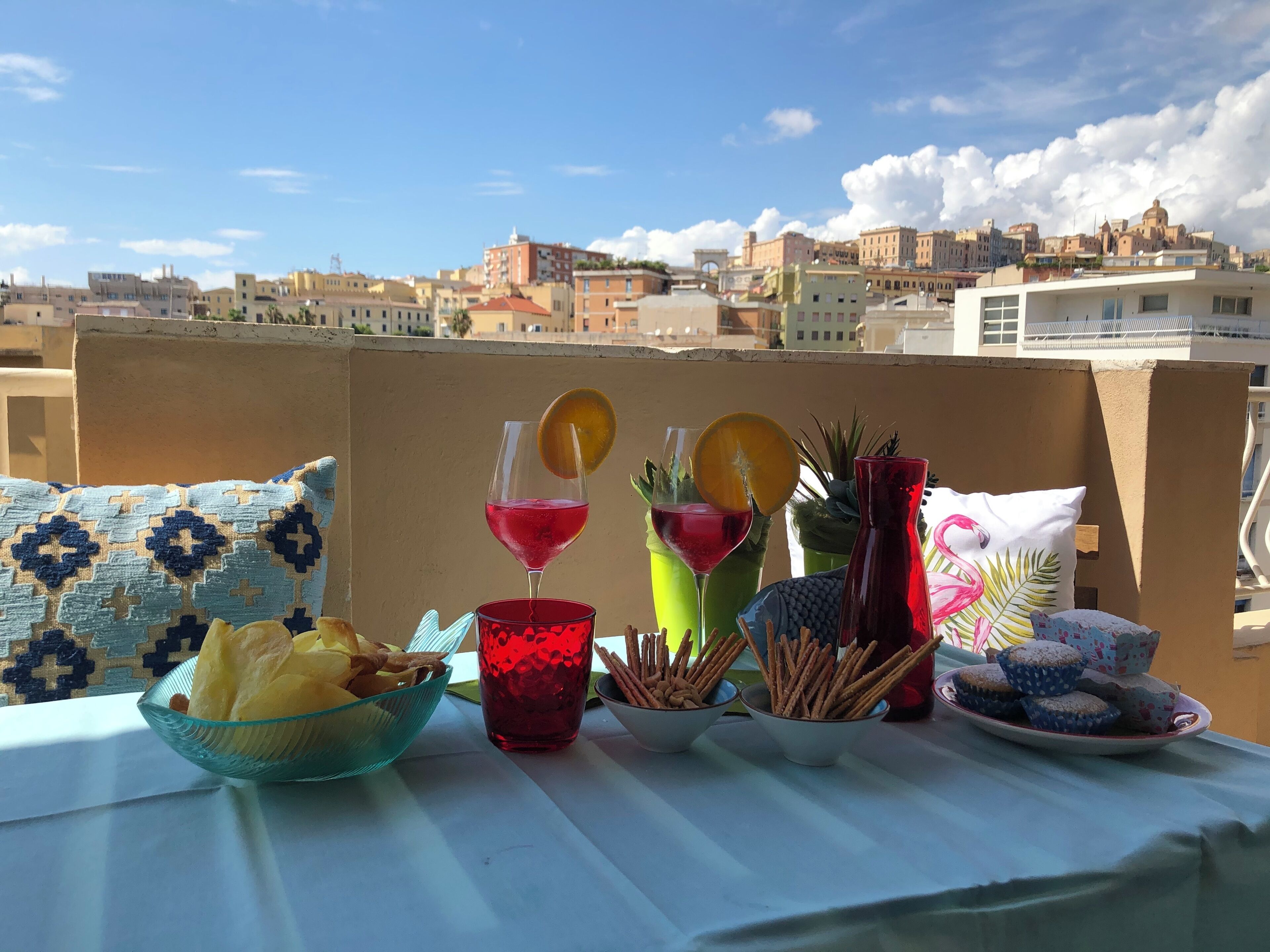 Una mesa servida con bocadillos, bebidas y vistas a un paisaje urbano.