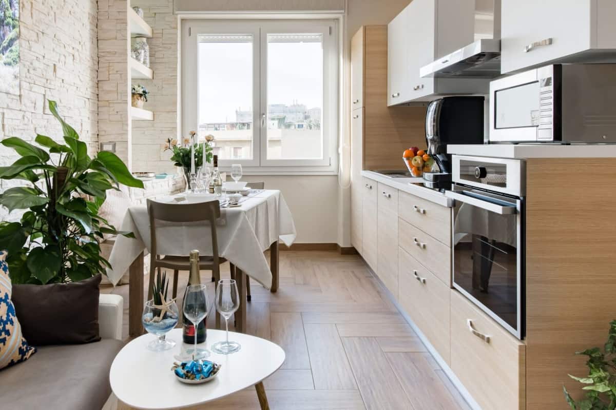 Una cucina moderna con forno integrato, microonde e una finestra con vista sulla città.