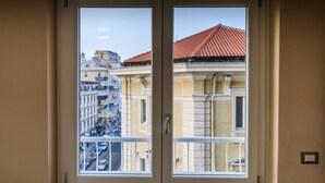 A window with a view of a cityscape, including buildings with red-tiled roofs and balconies. - Cagliari Magica (Cagliari)