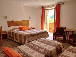 A bedroom with two beds, a wooden headboard, a balcony with red curtains, and a small table. - Hôtel Bellier (La Chapelle-en-Vercors)