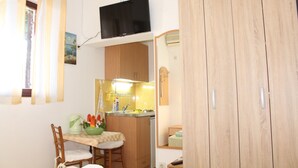 A small, compact room with a kitchenette, a dining area, and a wardrobe. - Guest House Tomanovic (Herceg Novi)