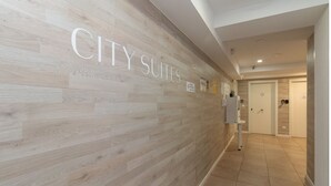 A hallway with a wooden wall displaying "CITY SUITES" and a door labeled "3". - Bet Apartments - Abastos (Valencia)