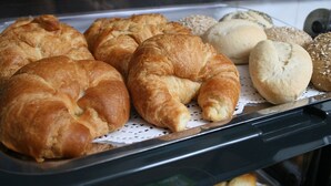 Une variété de produits de boulangerie est exposée, notamment des croissants et du pain.