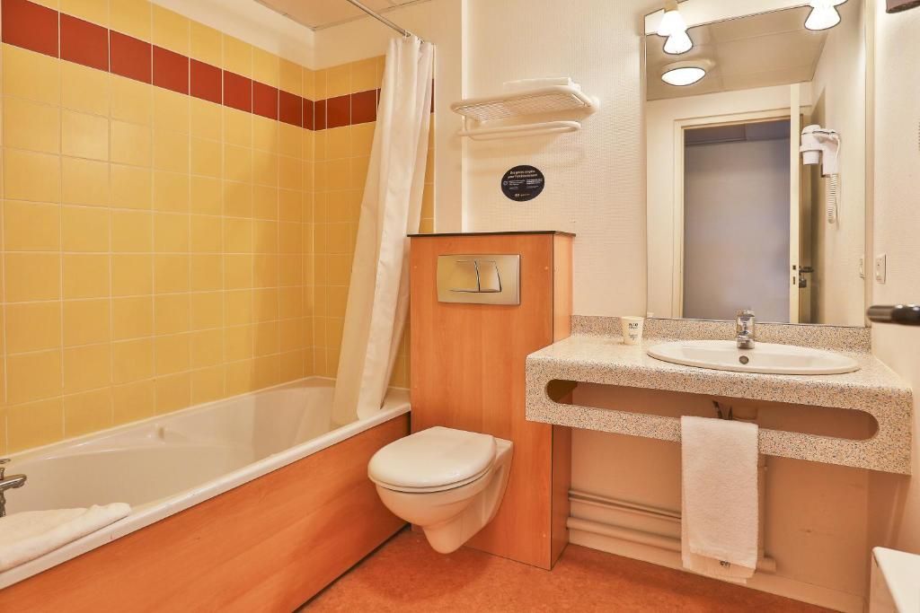 A bathroom with a bathtub, toilet, and sink.