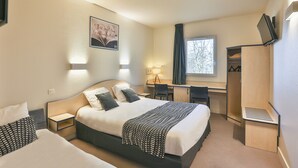 Een hotelkamer met een groot bed, een bureau, een stoel, een kledingkast en een raam.