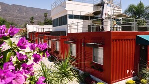 A modern building with a red and white color scheme, featuring balconies and a spiral staircase. - Hotel del Pescador (Jocotepec)