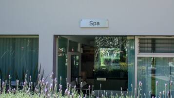 L'ingresso di una spa, con un cartello e piante di lavanda tutt'intorno.