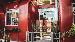 A red building with a metal gate and potted plants. - Hotel del Pescador (Jocotepec)