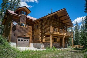 A log cabin with a balcony, a garage, and a satellite dish. - Silver Gate Lodging (Silver Gate)