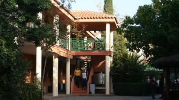 A building with a covered entrance, a staircase, and a large metal container.