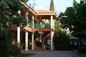 A building with a covered entrance, a staircase, and a large metal container. - Hostel Layos, Toledo (Layos)
