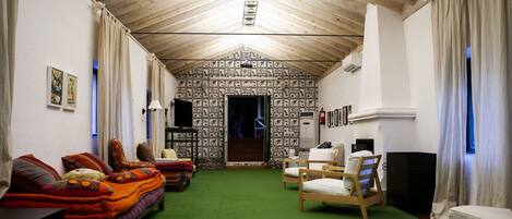 Ein gemütliches Zimmer mit einem grünen Teppich, Holzmöbeln und einer Wand mit Muster.