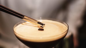 A martini glass with a foamy top, a dropper, and a pair of chopsticks resting on the rim. - ibis Styles Paris Meteor Avenue d'Italie (Paris)