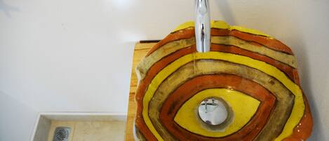 Ein rundes, mehrfarbiges Keramikstück mit konzentrischen Ringen, auf einer Holzfläche befestigt.