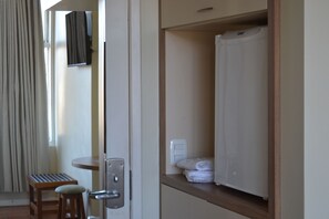 A hotel room with a wooden bench, a white door, and a small table. - Hotel Maerkli (Santo Angelo)