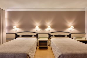 A hotel room with two beds, a nightstand, and wall-mounted lamps. - Hotel Maerkli (Santo Angelo)