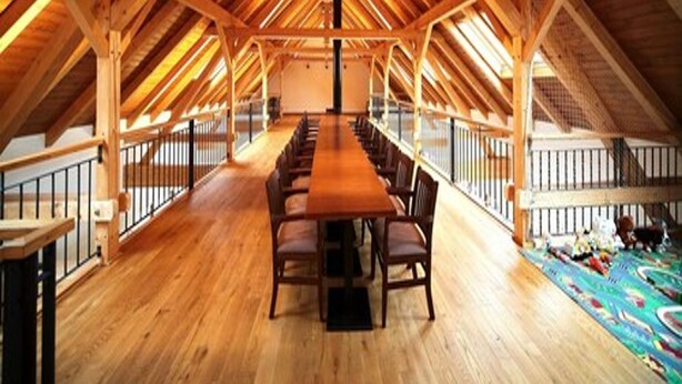 A spacious attic room with a high wooden ceiling and a long wooden table with chairs. - Statek 1738 (Vsestudy)