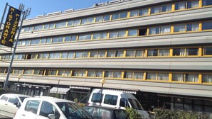 A multi-story building with a row of windows and a sign for a restaurant. - Residence Capitol (Trento)