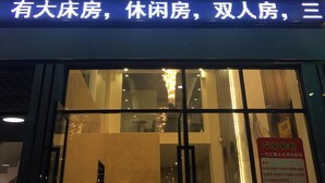 A hotel sign with illuminated text indicating the availability of large, short-term, and double rooms. - First Apartment (Jiangmen)