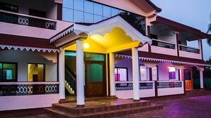 A multi-story building with a balcony, a staircase, and a covered entrance area. - Eve Resort (Canacona)