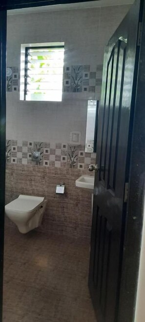 A bathroom with a toilet, bidet, and sink. - Eve Resort (Canacona)