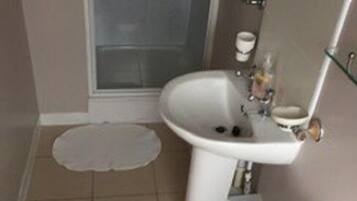 A bathroom with a toilet, sink, and shower.