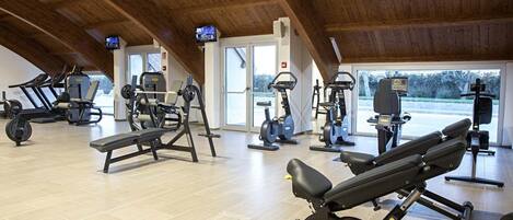 A gym with various exercise equipment, including treadmills, elliptical machines, and weight machines.