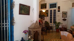 Un salon chaleureux avec une porte bleue, un meuble en bois, une chaise, une table et une plante en pot.