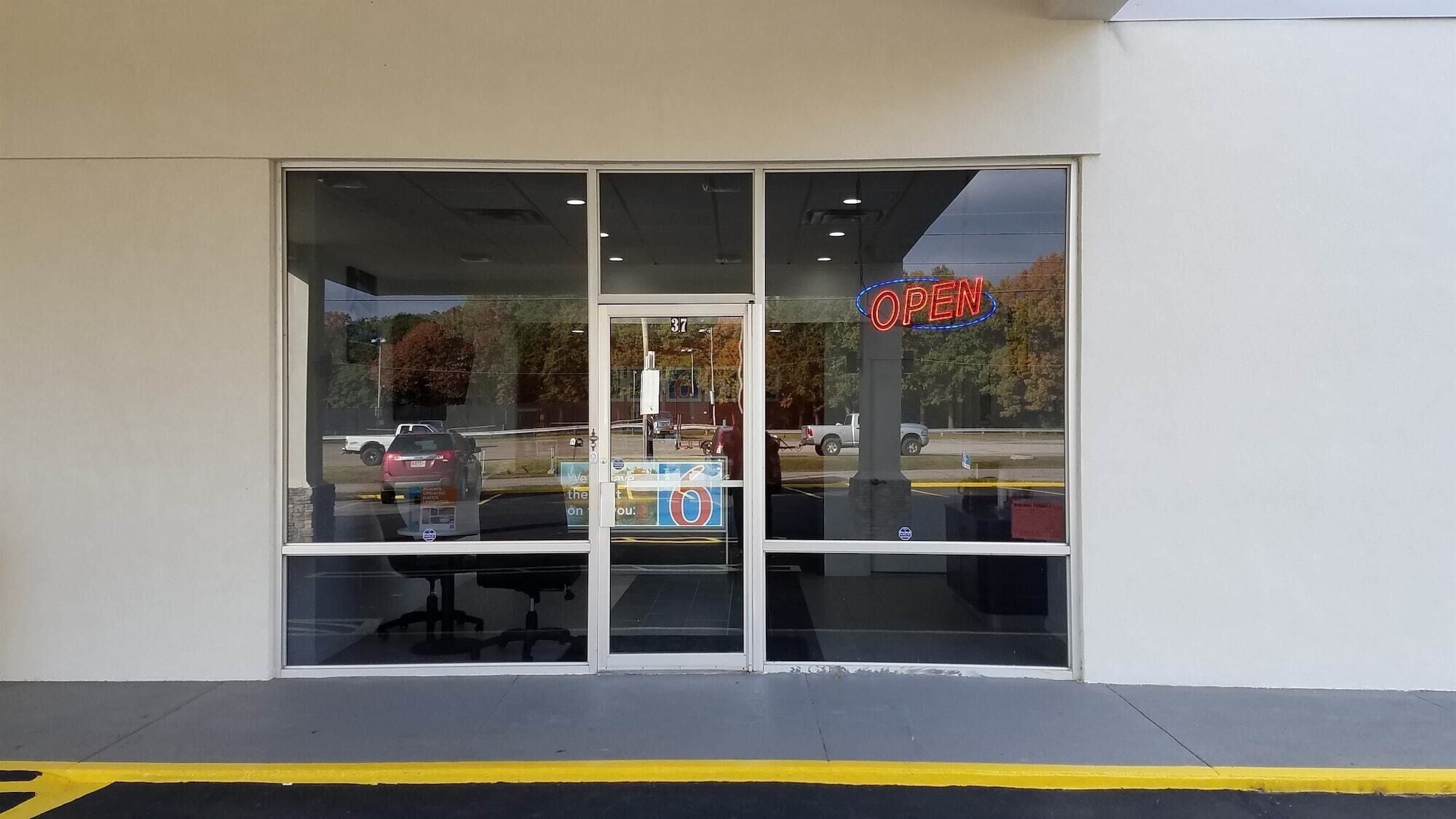 A storefront with a large glass window and a neon 'OPEN' sign.