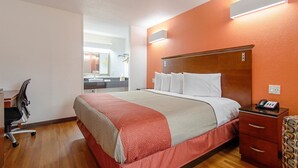 A hotel room with a bed, a desk, and a chair.