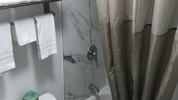 Un baño con inodoro, bañera y cortina de ducha.