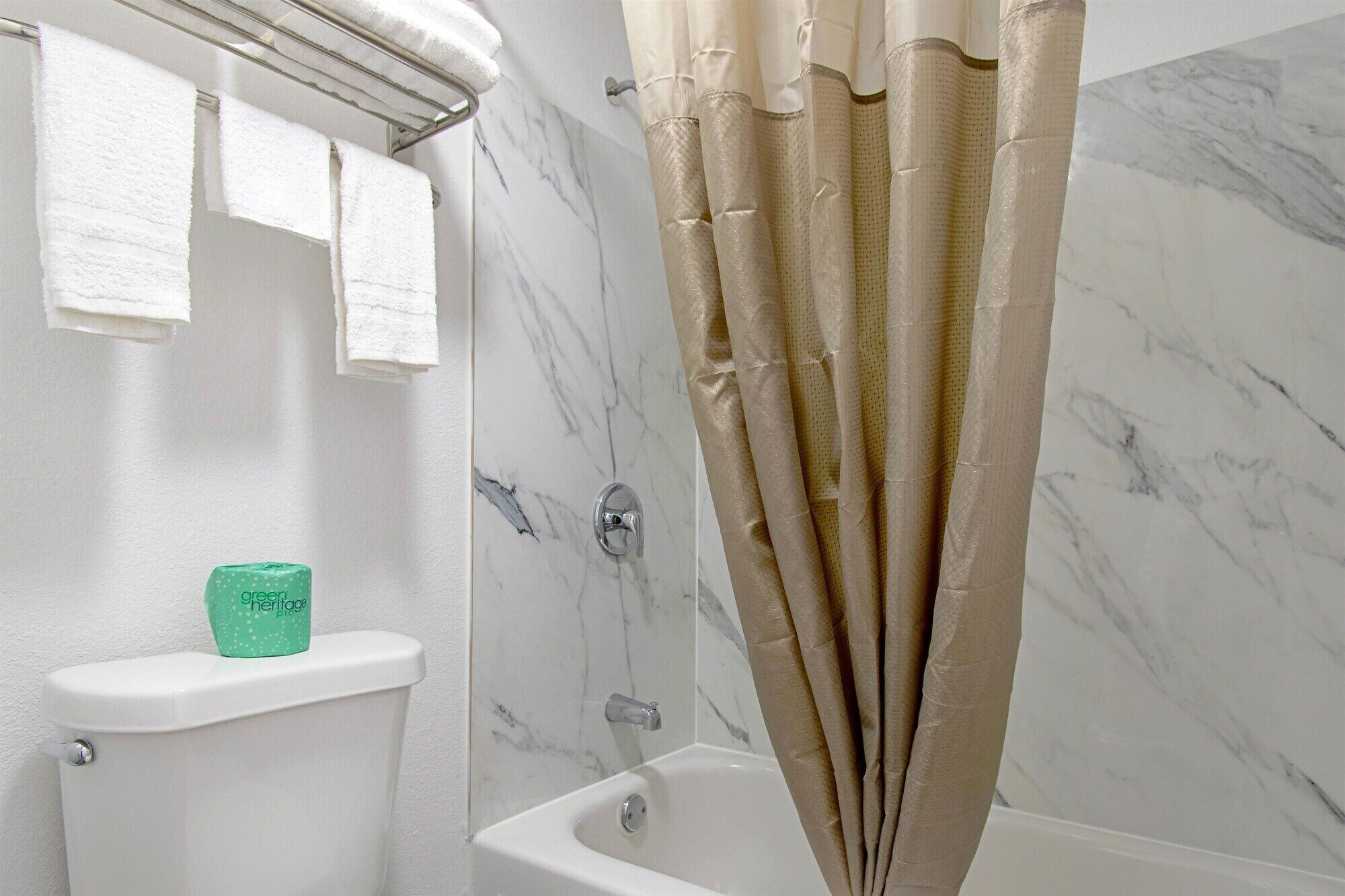 A bathroom with a bathtub, a toilet, and a shower curtain.