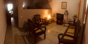 A living room with a television, two chairs, a table, and a fan. - Hostal plaza (Cienfuegos)