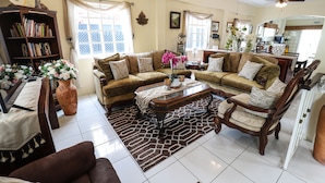 A spacious living room with a sectional sofa, a coffee table, and a bookshelf.