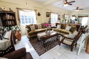 Habitación triple Confort, varias camas, frigorífico | Zona de estar | Una televisión