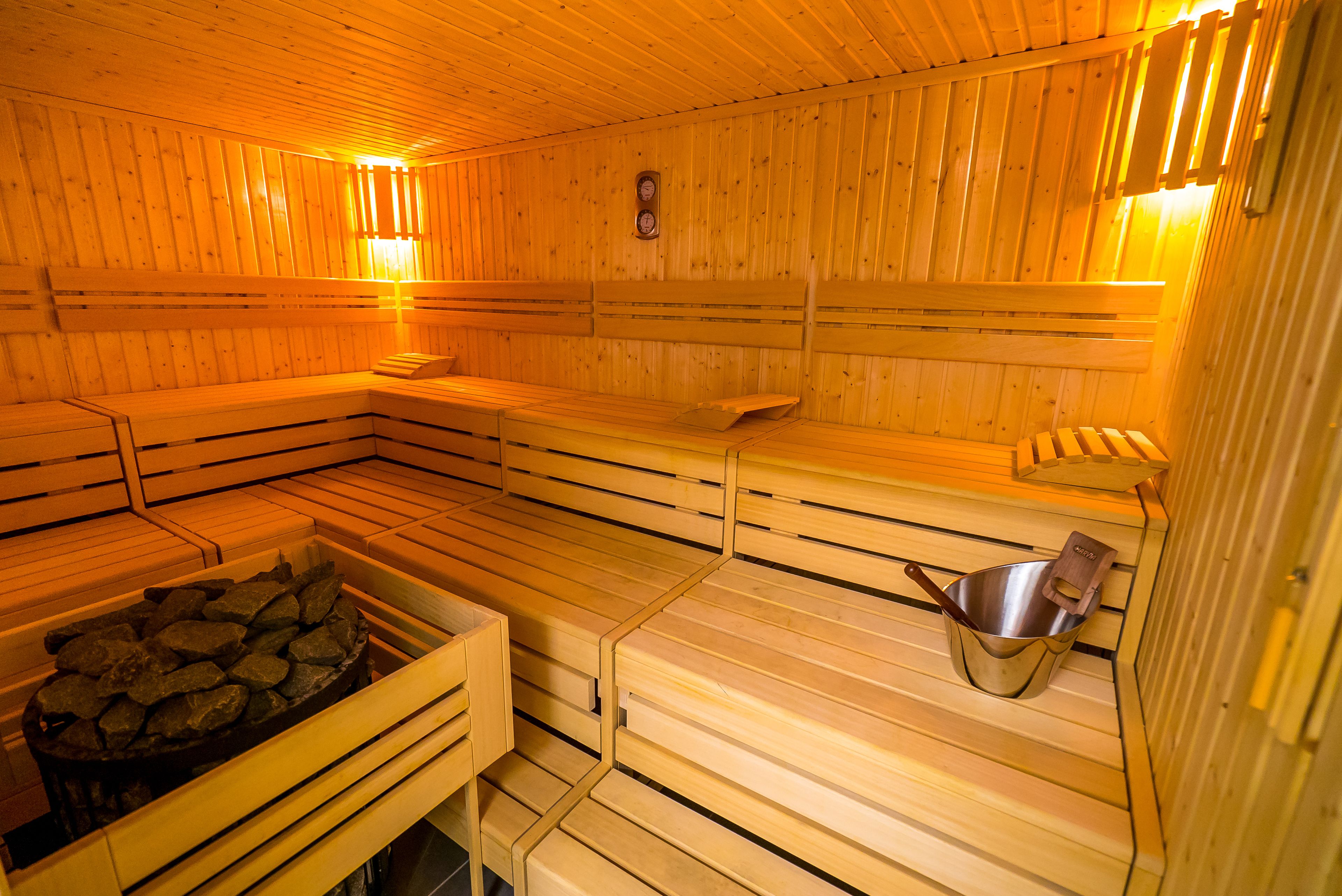 Eine Sauna mit Holzbänken und einer Steinschaukel.