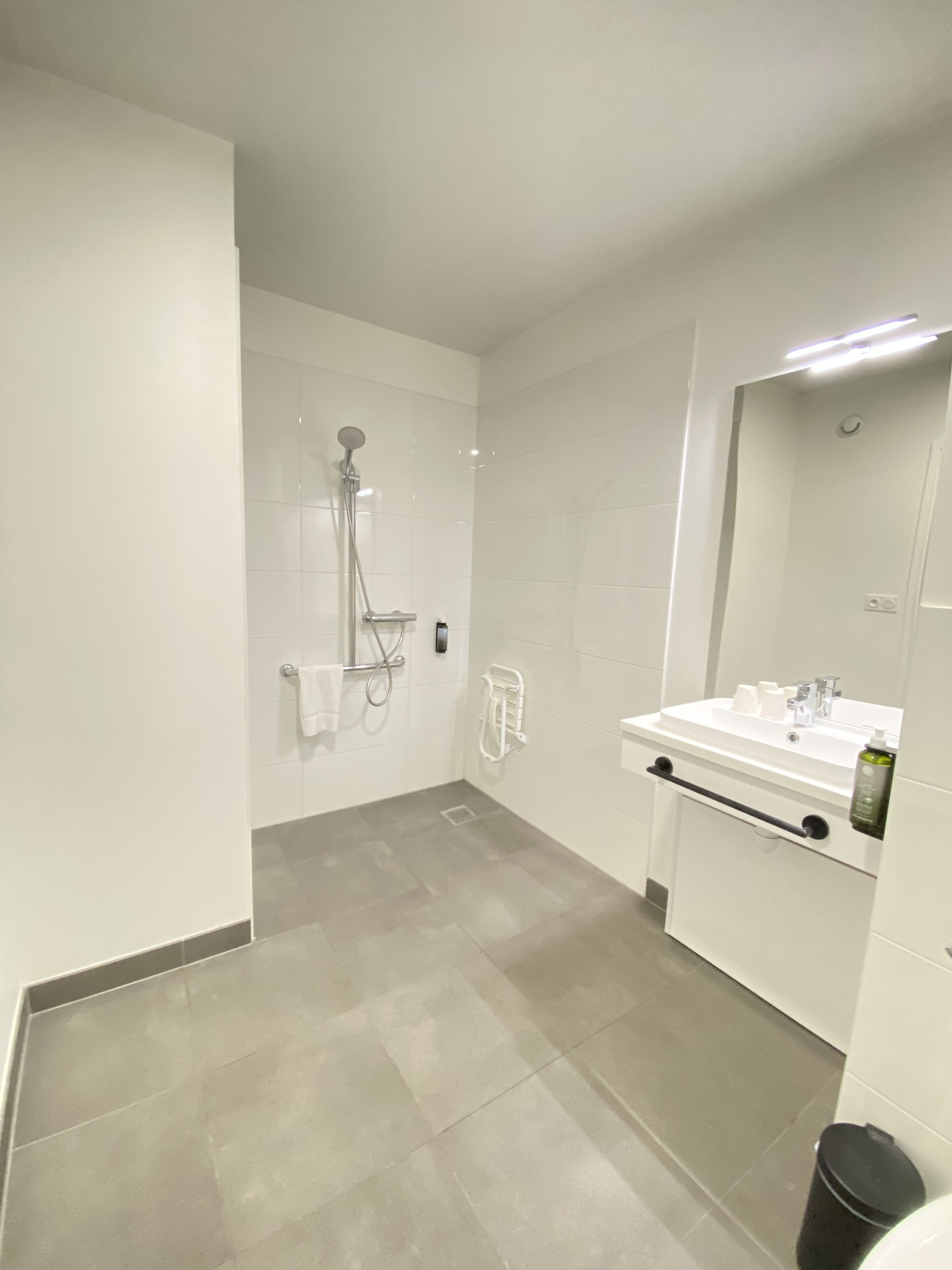 Ein modernes Badezimmer mit Dusche, Waschbecken und Spiegel.
