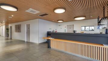 A modern reception area with a wooden ceiling, a reception desk, and a clean, minimalist design.