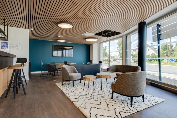 A modern interior with a wooden ceiling, bar area, seating, and large windows. - All Suites Appart Hôtel | Palaiseau - Massy TGV (Palaiseau)