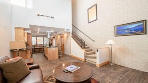 A spacious living area with a sofa, coffee table, and a staircase leading to an upper level. - Stylish Park City 2BR Sleeps 6-Walk to Park City Resort, Shops & Dining (Park City)