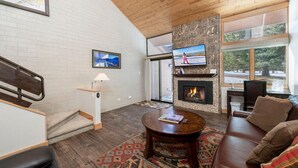 A living room with a fireplace, a television, and a large window. - Stylish Park City 2BR Sleeps 6-Walk to Park City Resort, Shops & Dining (Park City)