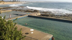 En swimmingpool med udsigt til havet og stranden.