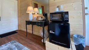 Une cuisine compacte équipée d’un four à micro-ondes, d’une machine à café et d’un petit réfrigérateur.