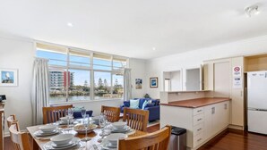 A modern apartment with a dining area, kitchen, and living space. - Mandurah Overlooking The Marina (Mandurah)