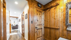 A wooden hallway with a coat rack, a door labeled "RC", and a bench. - Exquisitely appointed-2BR+Loft-walk to Three Kings lift with private hot tub (Park City)