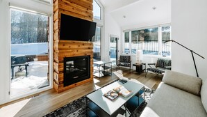 A modern living room with a fireplace, large windows, and a cozy seating area. - Stylish Park City 2BR, Walk to Three Kings Lift, Heated Pool & Hot Tub (Park City)