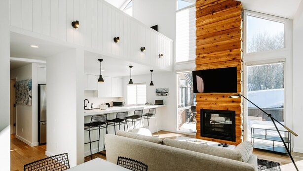 A modern kitchen with white cabinets, a dining area with a white table and chairs, and a cozy seating area with a sofa. - Stylish Park City 2BR, Walk to Three Kings Lift, Heated Pool & Hot Tub (Park City)