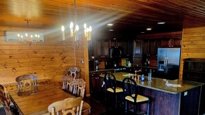 Un intérieur en bois comprenant un coin repas, une cuisine et un bar.
